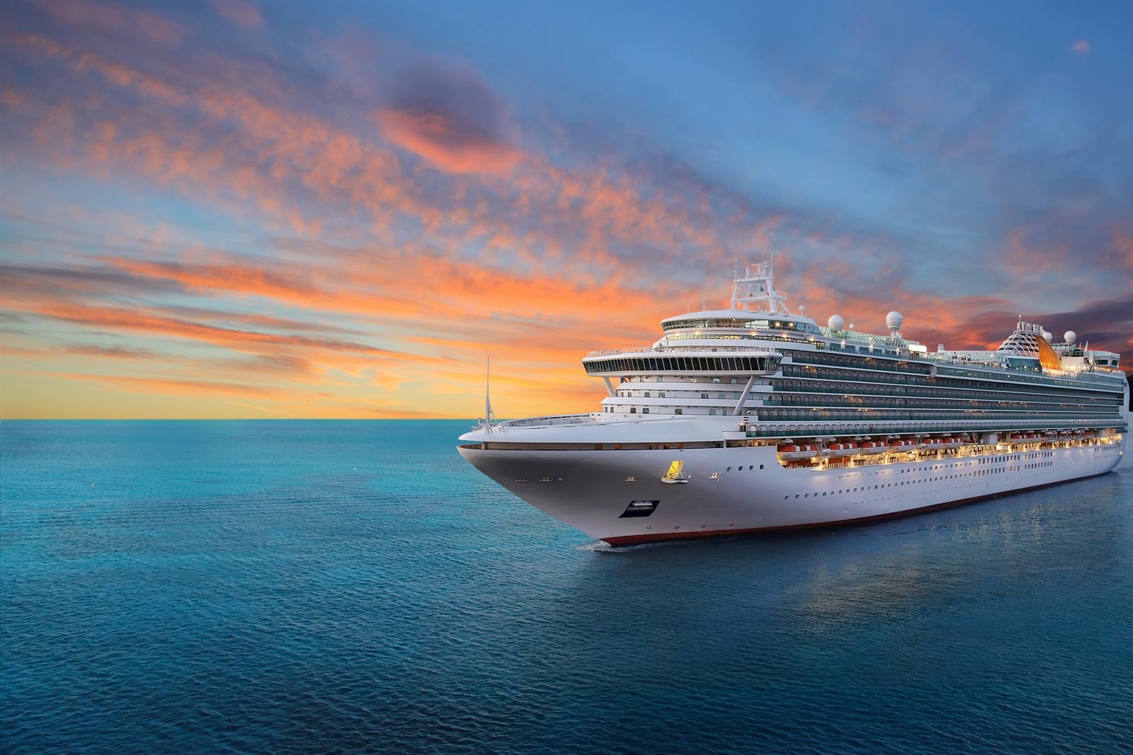 Cruise ship sailing on calm water at sunset