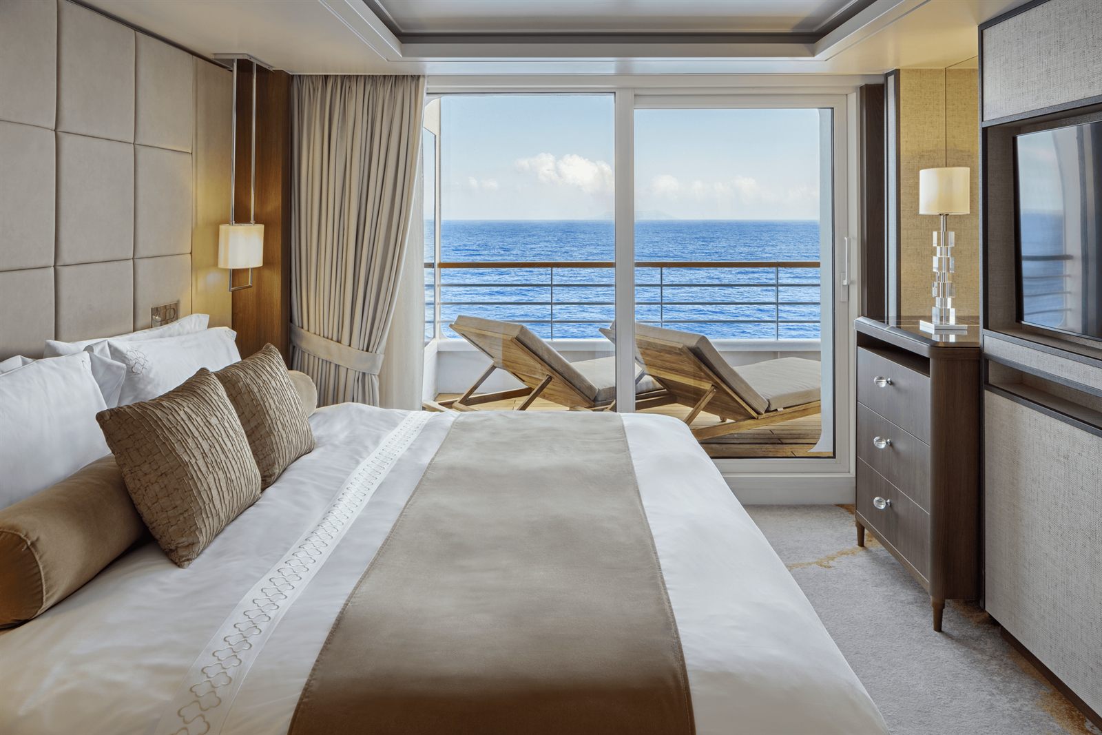 Cruise cabin bedroom opening onto a balcony
